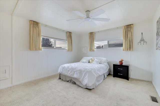 a bedroom with a bed and a painting on the wall