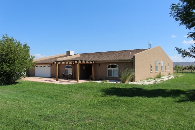 853 R Road Mack, CO 81525 - Photo 11 of 42 a front view of a house with a yard and garage