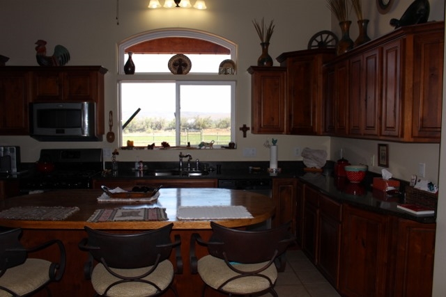 853 R Road Mack, CO 81525 - Photo 29 of 42 a kitchen with granite countertop a stove a sink dishwasher and cabinets with wooden floor
