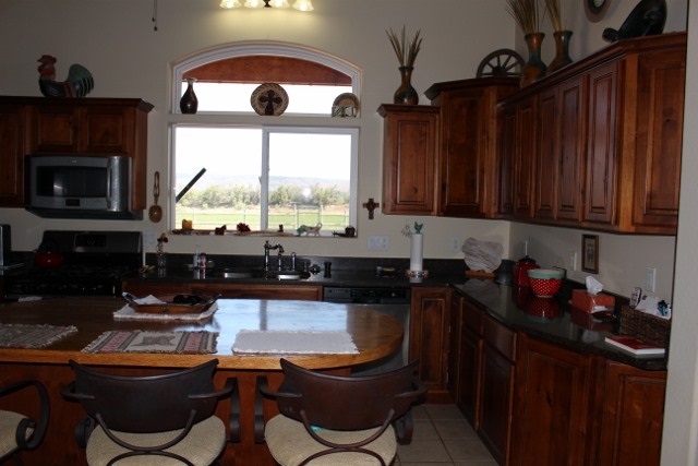 853 R Road Mack, CO 81525 - Photo 33 of 42 a kitchen with granite countertop a stove a sink and a microwave