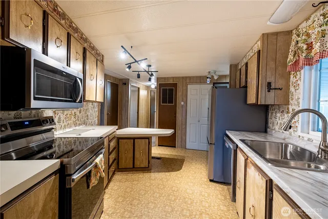 a kitchen that has a sink a stove and a oven
