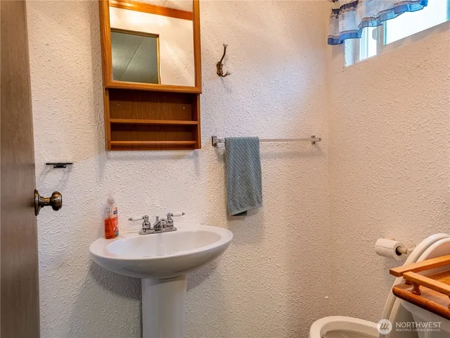 a bathroom with a sink a toilet and mirror