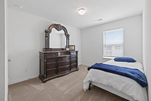 a bedroom with a bed and a dresser