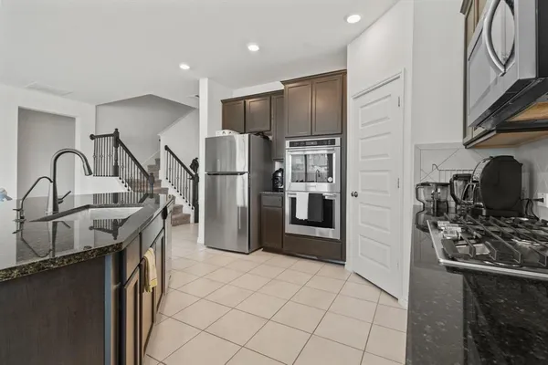a kitchen with stainless steel appliances granite countertop a refrigerator and a stove top oven