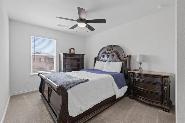 a spacious bedroom with a bed and a dresser in it