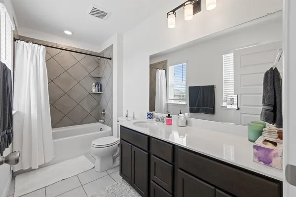 a bathroom with a double vanity sink toilet mirror and shower