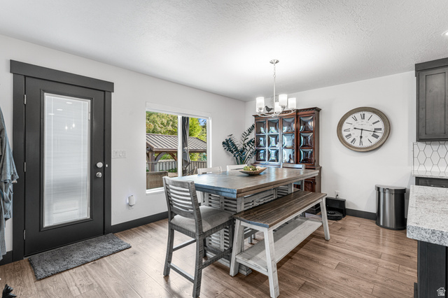 313 Old Maple Road South Weber, UT 84405 - Photo 10 of 35 Wood-finish flooring throughout a dining area with a dark-framed glass-paneled exterior door