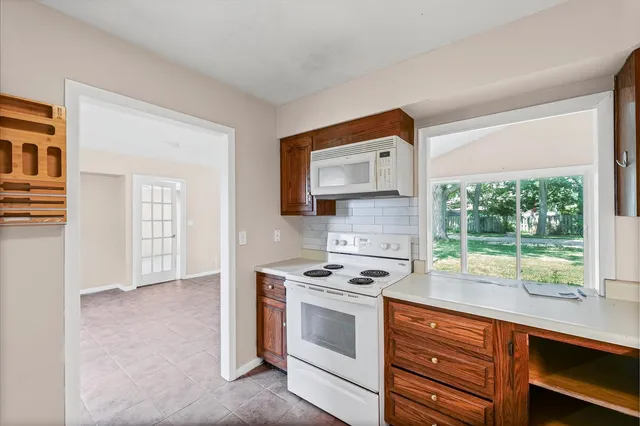 an empty room with wooden floor closet and windows
