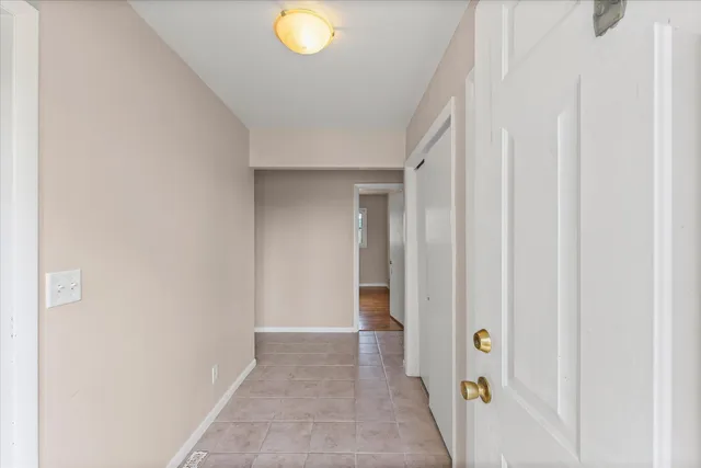 a view of an empty room with window and fire place