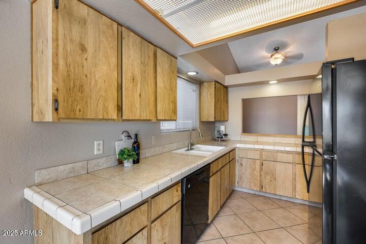 3339 West Mohawk Lane Phoenix, AZ 85027 - Photo 5 of 27 a kitchen with a sink a refrigerator and cabinets