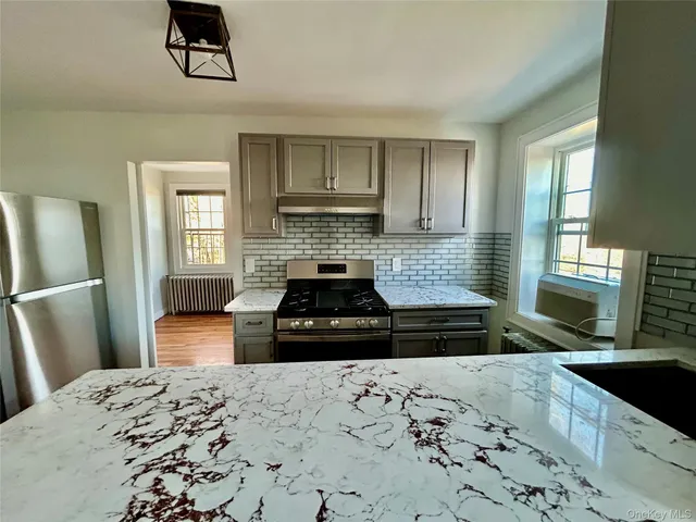 a kitchen with a stove a refrigerator a sink a stove and wooden floor