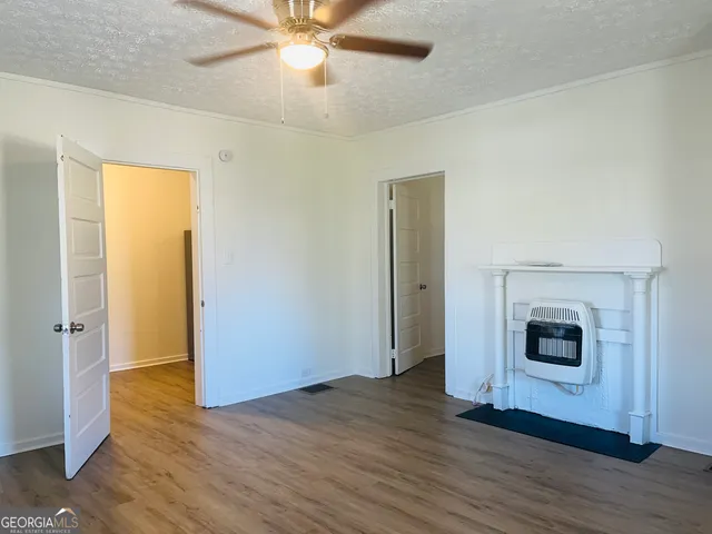 a view of a livingroom with wooden floor and a ceiling fan