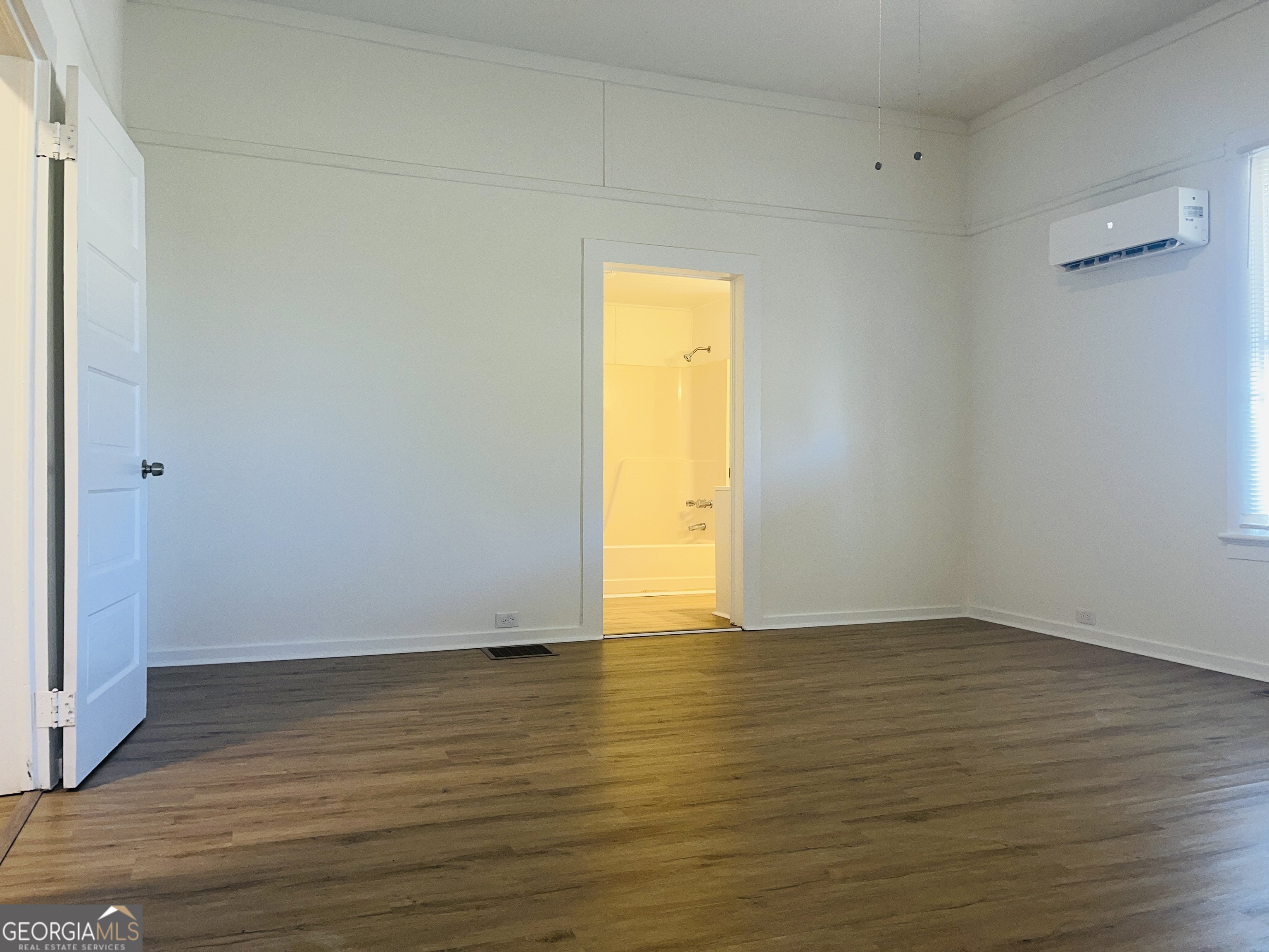1203 1st Avenue, Unit A LaGrange, GA 30240 - Photo 14 of 17 a view of an empty room and wooden floor and a window