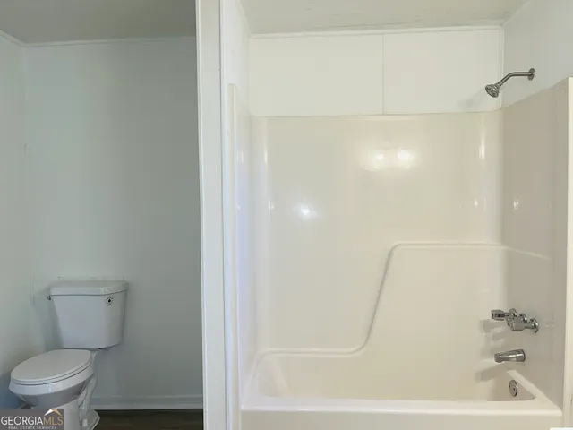 a bathroom with a toilet and a shower