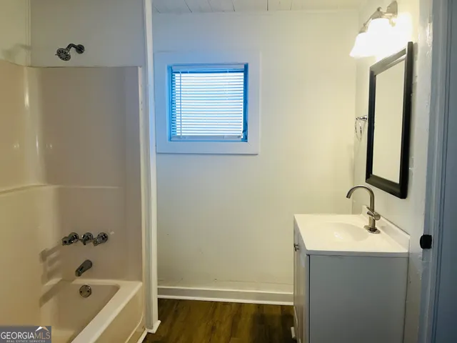 a bathroom with a tub sink and mirror