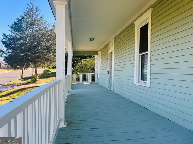 a view of a balcony with wooden floor and fence