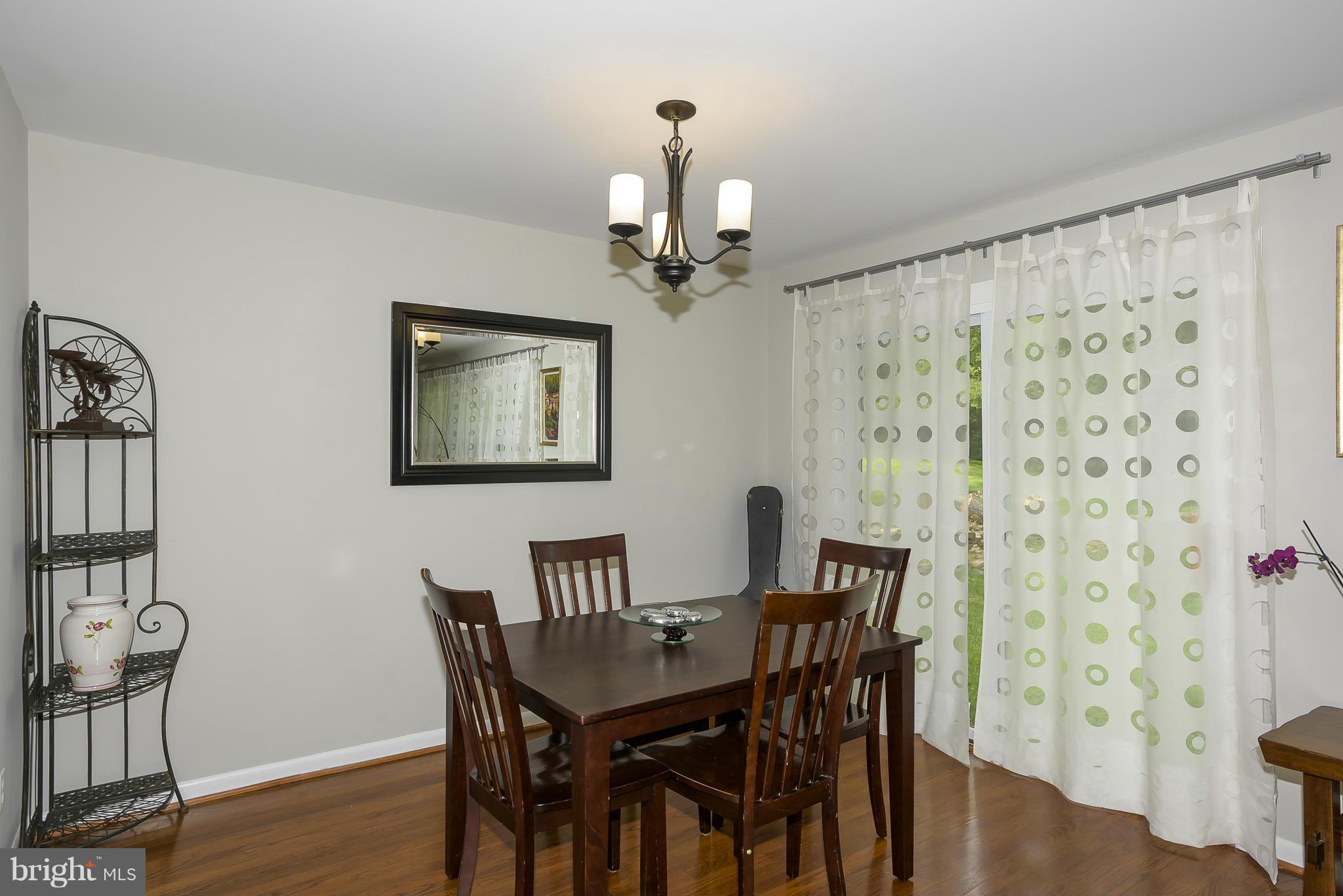 13007 Broadmore Road Silver Spring, MD 20904 - Photo 7 of 30 a view of a dining room with furniture wooden floor and a chandelier
