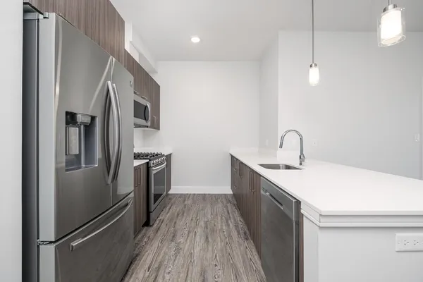 a kitchen with sink a refrigerator and wooden floor