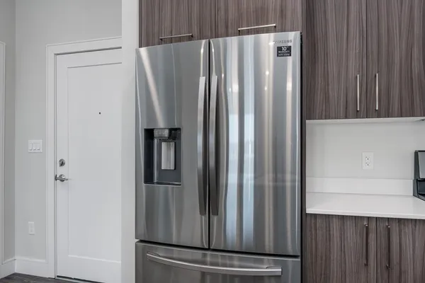 a view of kitchen with refrigerator and cabinet