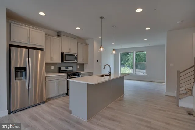 a kitchen with refrigerator cabinets and wooden floor