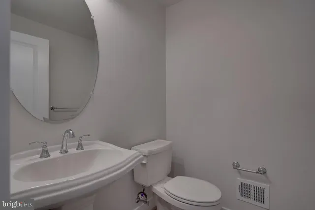 a white toilet sitting next to a bathroom sink