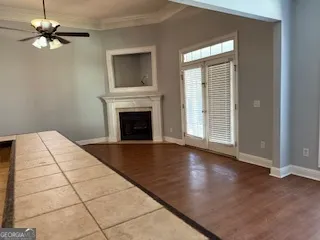 a view of an empty room with chandelier fan and fire place
