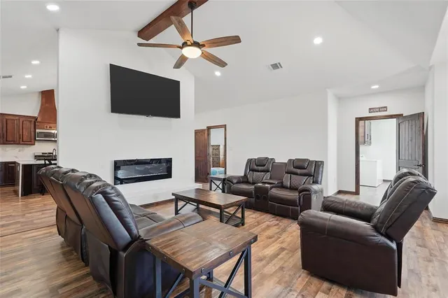 a living room with furniture a flat screen tv and a fireplace