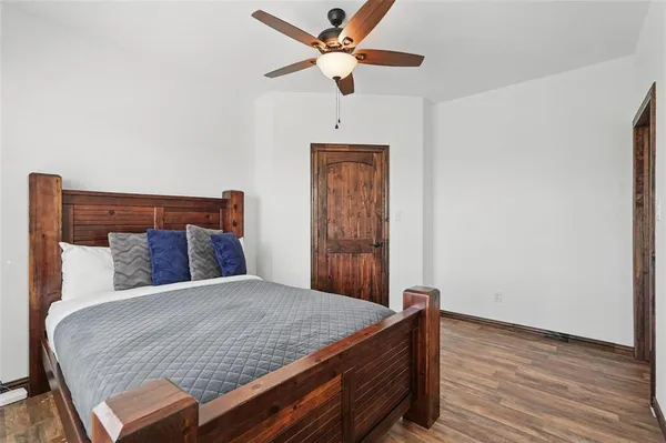a bedroom with a bed and a table with wooden floor