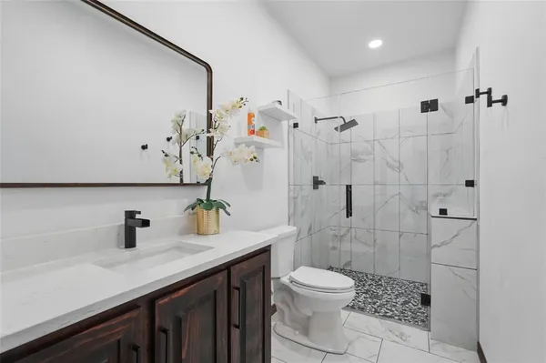 a bathroom with a sink a toilet and shower