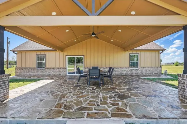 a view of a patio with table and chairs with wooden fence