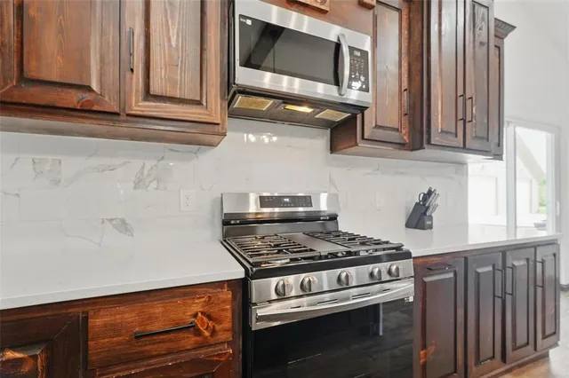 a kitchen with granite countertop a stove and a microwave