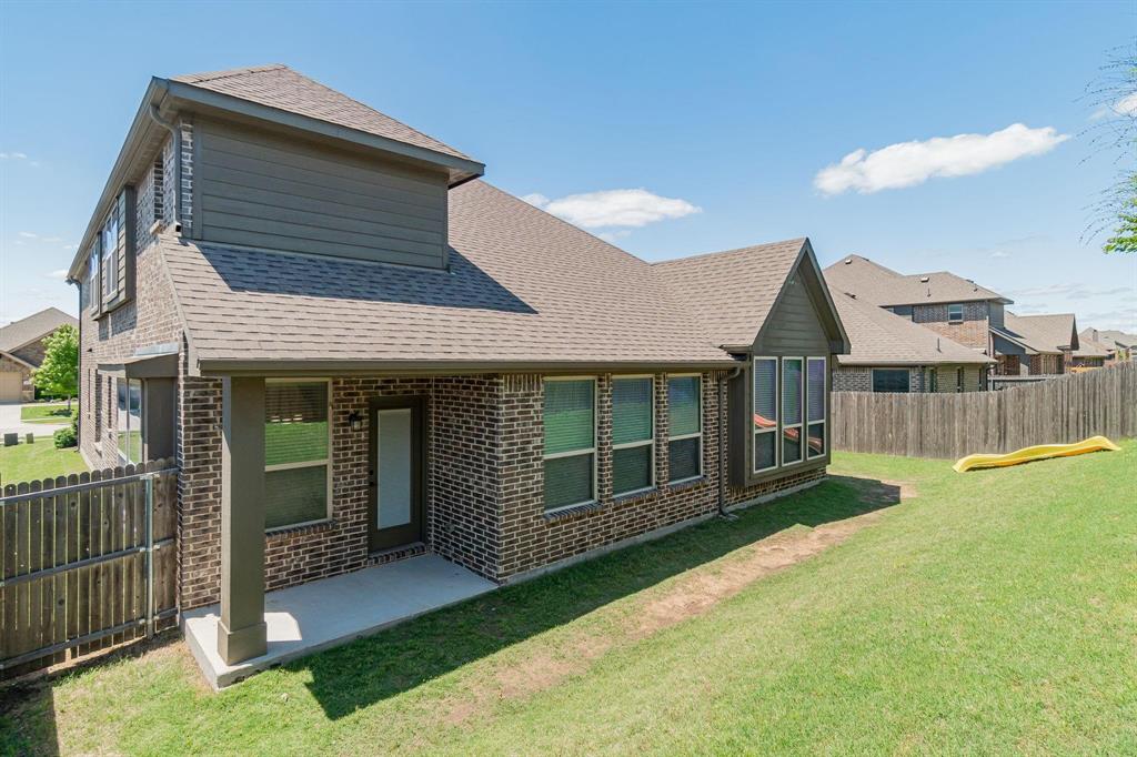 4210 Magnolia Road Melissa, TX 75454 - Photo 21 of 22 Brick exterior with gabled roofline, concrete patio, covered porch, and a fenced backyard