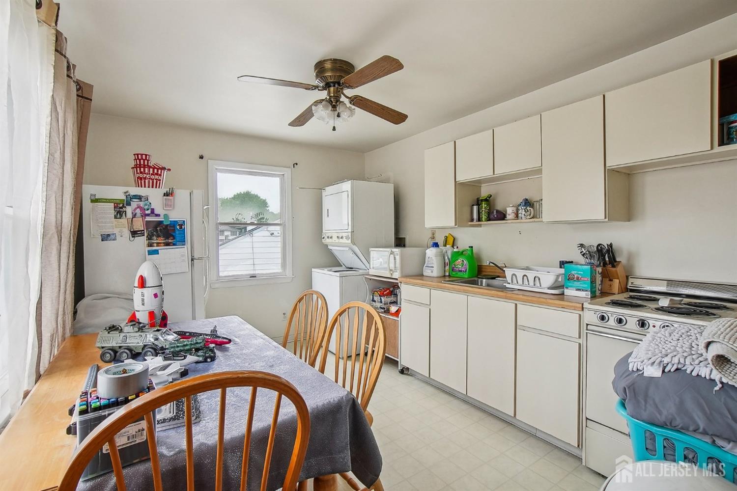 30 Kenmore Road Edison, NJ 08817 - Photo 12 of 25 a kitchen with stainless steel appliances granite countertop a dining table chairs refrigerator and sink