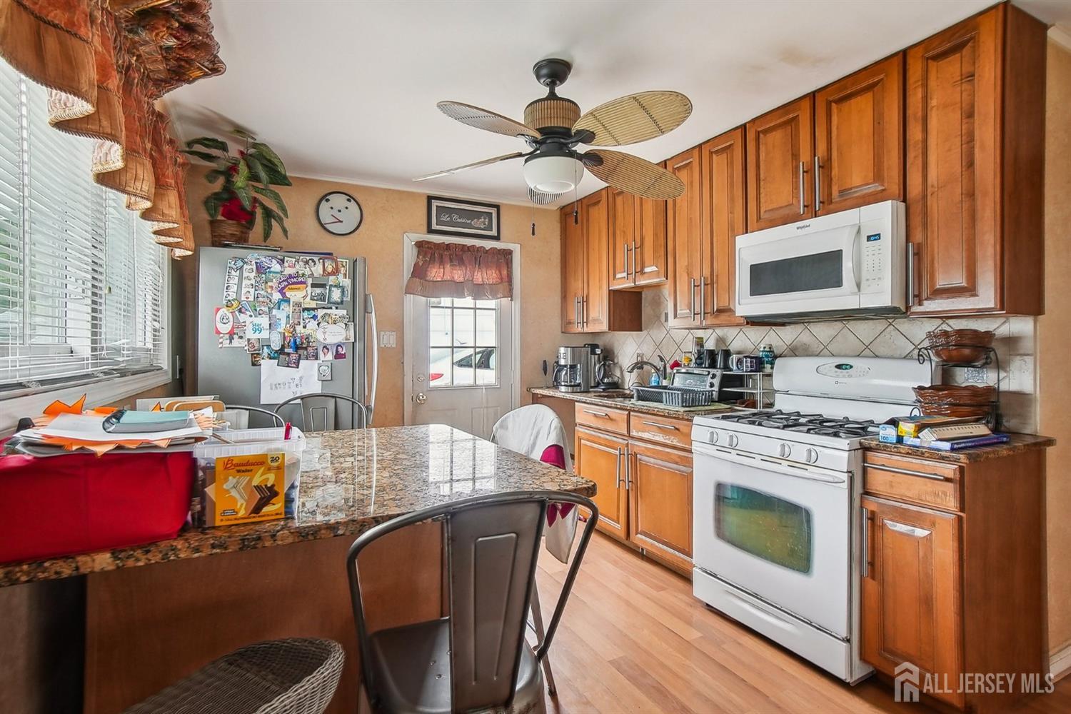 30 Kenmore Road Edison, NJ 08817 - Photo 4 of 25 a kitchen with stainless steel appliances granite countertop a stove a sink dishwasher and a dining table with cabinets