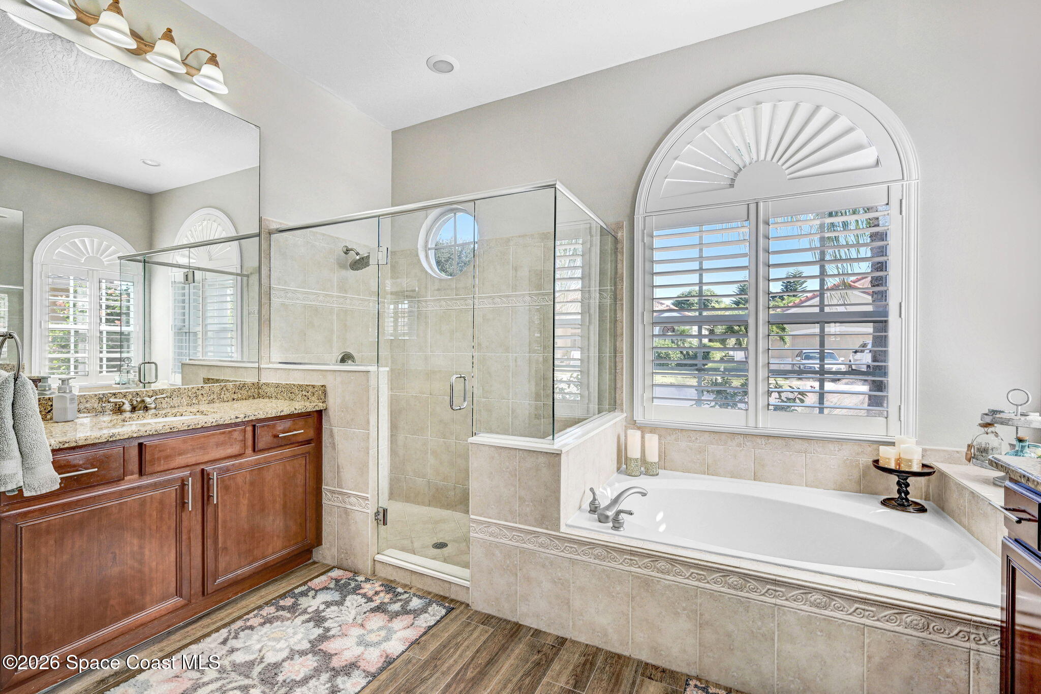 3330 Poseidon Way Indialantic, FL 32903 - Photo 23 of 47 a spacious bathroom with a granite countertop tub a sink and a large mirror