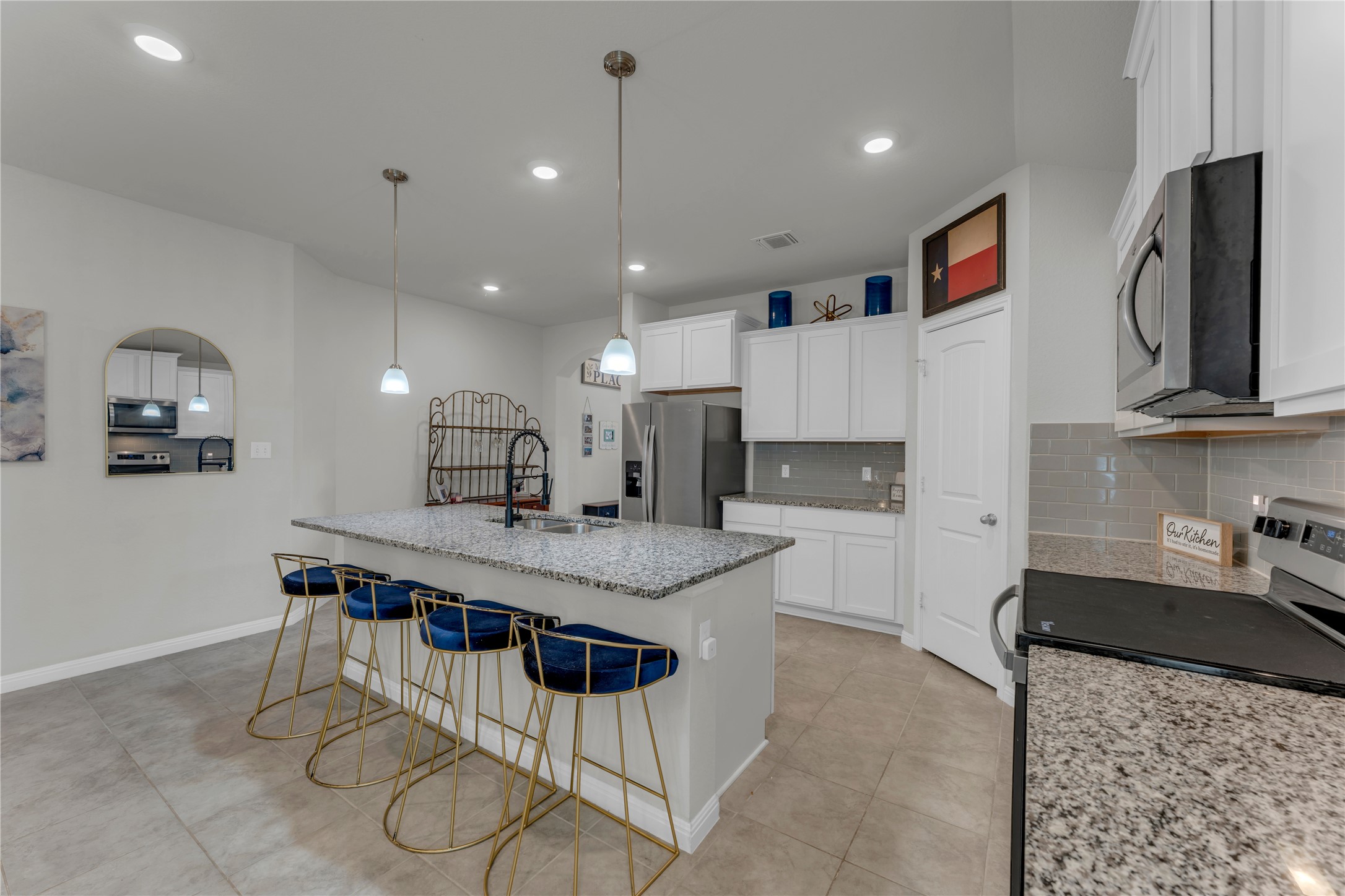 132 Cinnamon Loop Burnet, TX 78611 - Photo 6 of 27 Kitchen featuring a spacious island with a granite-style countertop, white cabinetry, integrated stainless steel appliances, a subway tile backsplash, and recessed lighting