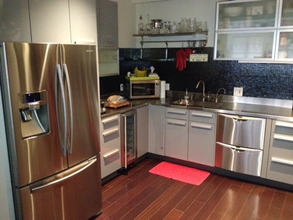 a kitchen with stainless steel appliances granite countertop a refrigerator sink and wooden floor