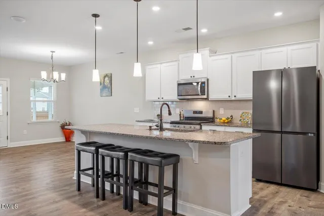 a kitchen with kitchen island appliances and wooden floor