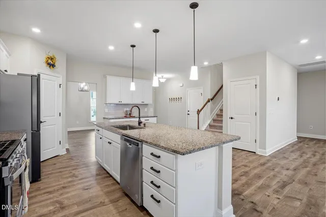 a kitchen with granite countertop a sink a center island and wooden floor
