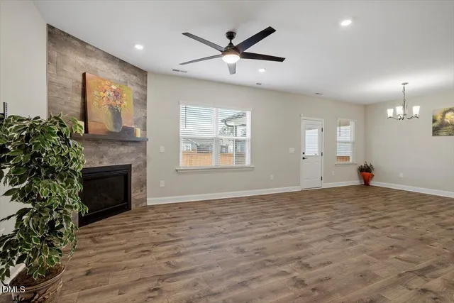 a living room with furniture a fireplace and a ceiling fan