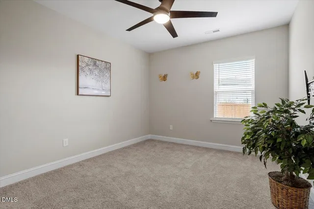 a view of an empty room with a ceiling fan