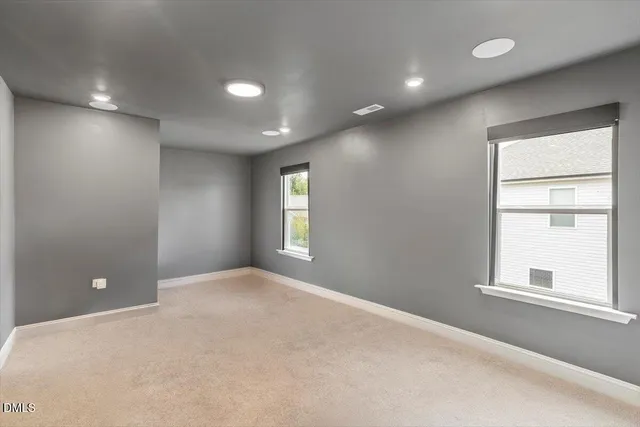 a bedroom with a large bed and paintings on the wall