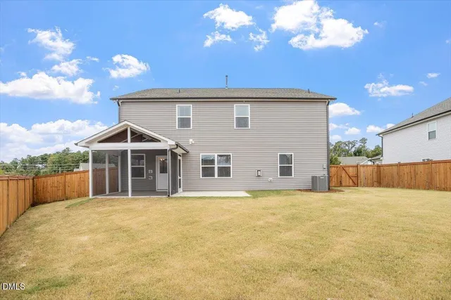 a view of house with backyard and glass windows