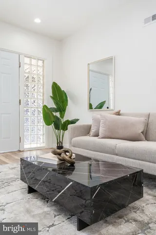 a living room with furniture a lamp and a potted plant