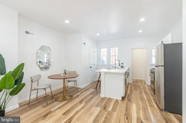 a kitchen with a sink appliances and a dining table