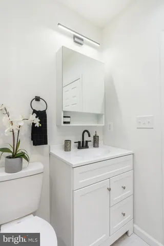 a bathroom with a granite countertop toilet sink and mirror