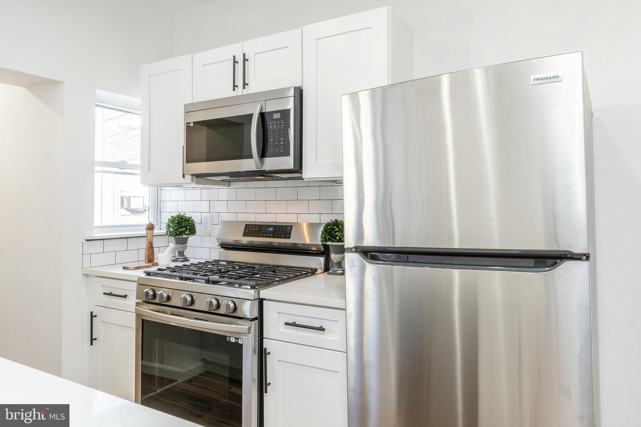 3312 North Bailey Street Philadelphia, PA 19129 - Photo 9 of 35 a kitchen with stainless steel appliances a refrigerator sink and microwave
