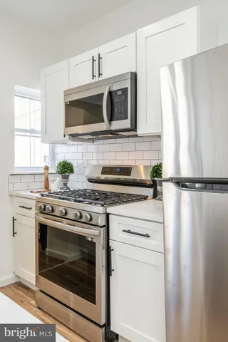 a kitchen with stainless steel appliances a stove a microwave and cabinets
