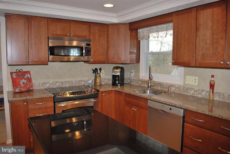 7837 Roundabout Way Springfield, VA 22153 - Photo 3 of 24 a kitchen with granite countertop a sink stove top oven and cabinets