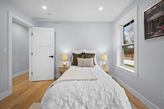 a bedroom with a bed and wooden floor